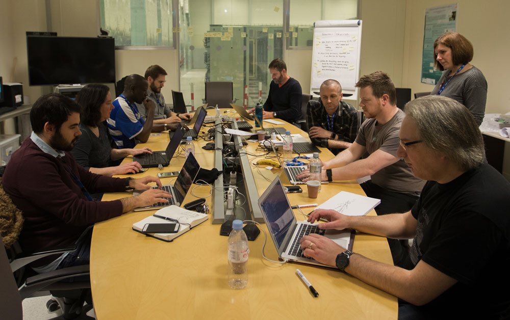Gathered at CERN, hunched over laptops.